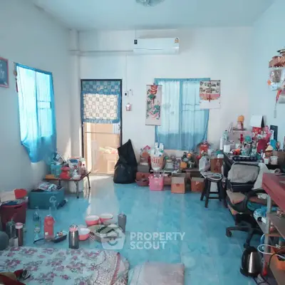 Cozy living room with blue accents and eclectic decor, featuring a comfortable seating area and vibrant atmosphere.