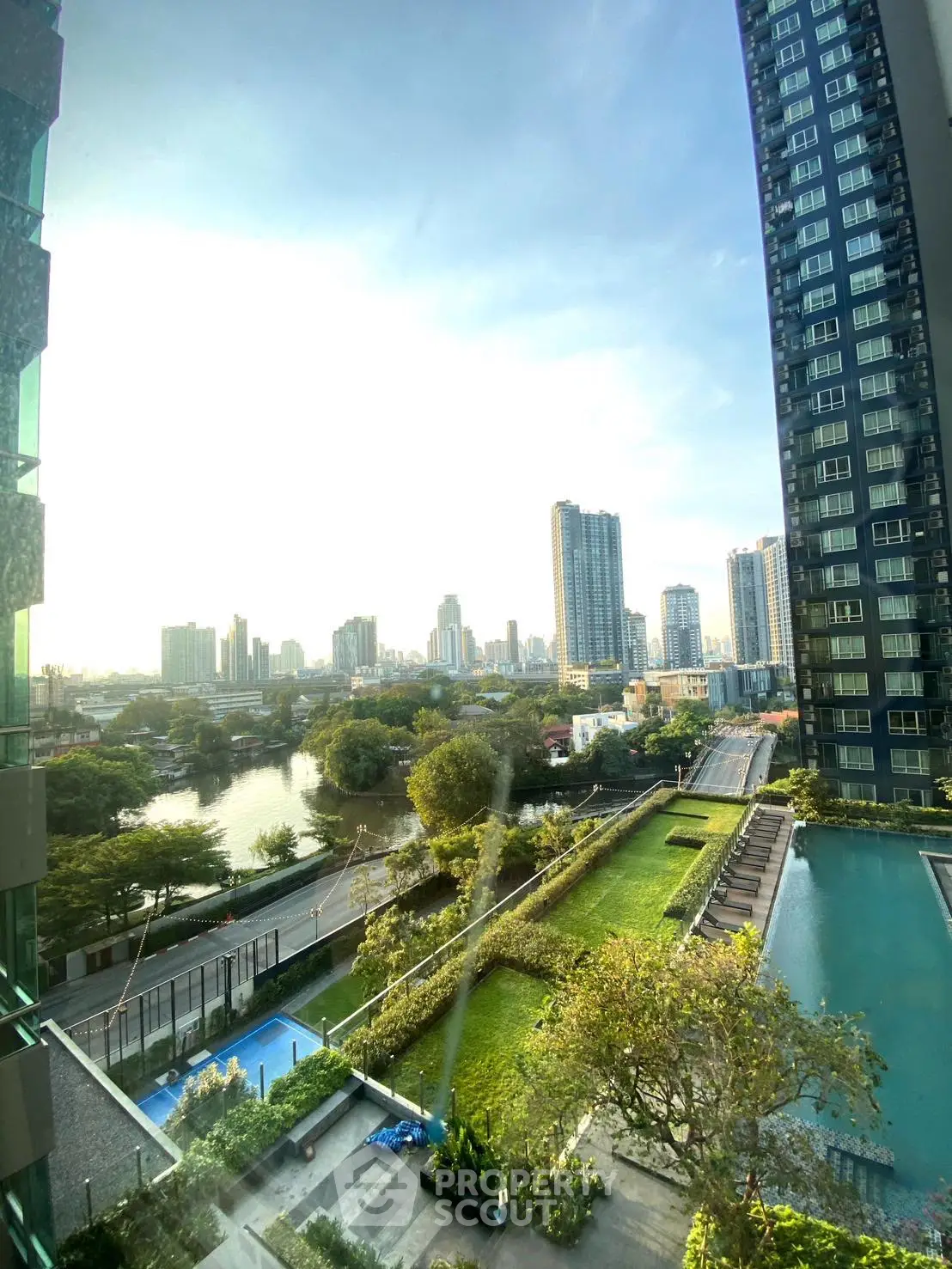 Stunning cityscape view from high-rise building with lush garden and pool