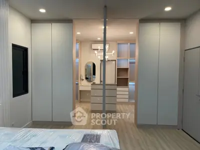 Spacious modern bedroom with elegant built-in wardrobes and stylish lighting