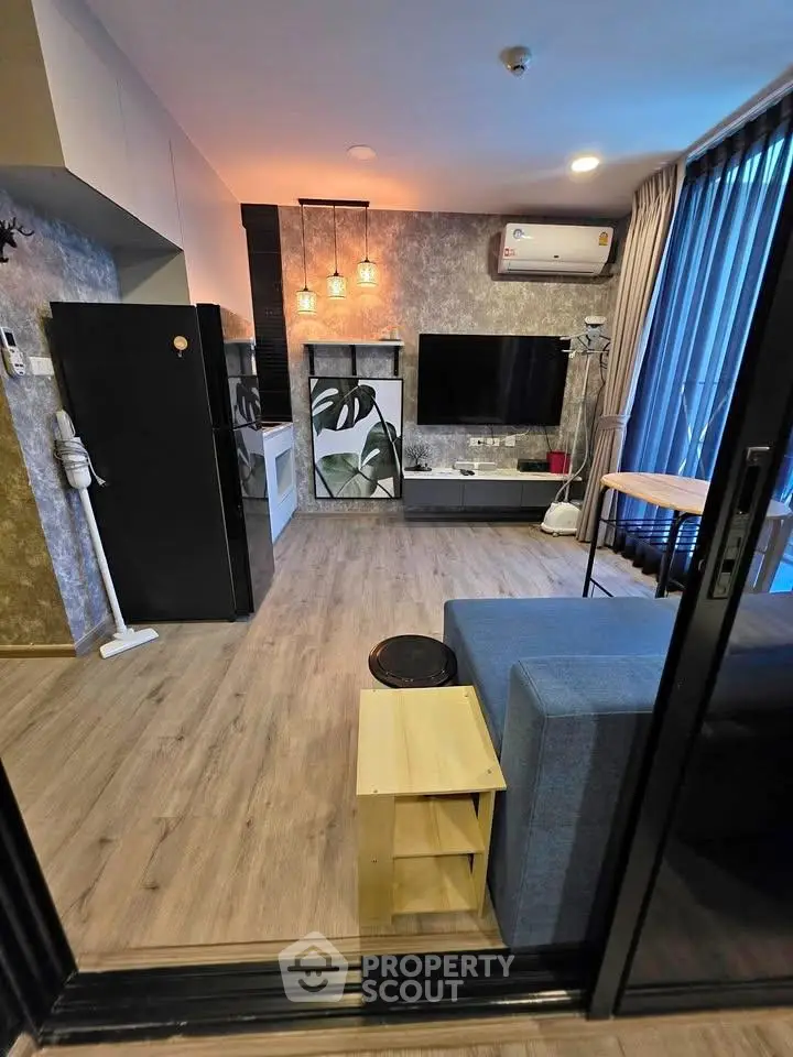 Modern living room with stylish decor, large TV, and open layout in a cozy apartment.