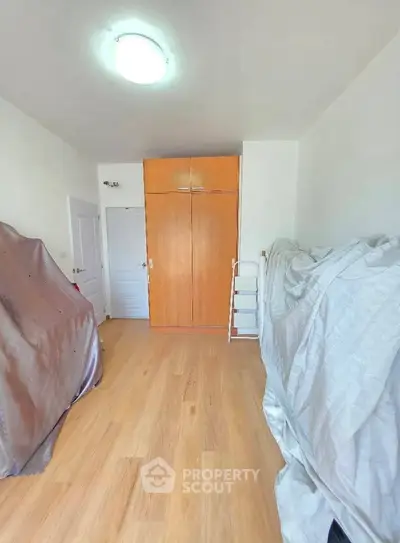 Spacious room with wooden flooring and built-in wardrobe, perfect for versatile use.