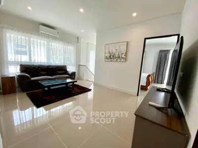 Spacious modern living room with sleek tile flooring and cozy seating area.