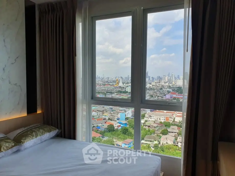 Stunning bedroom with panoramic city view through large windows.