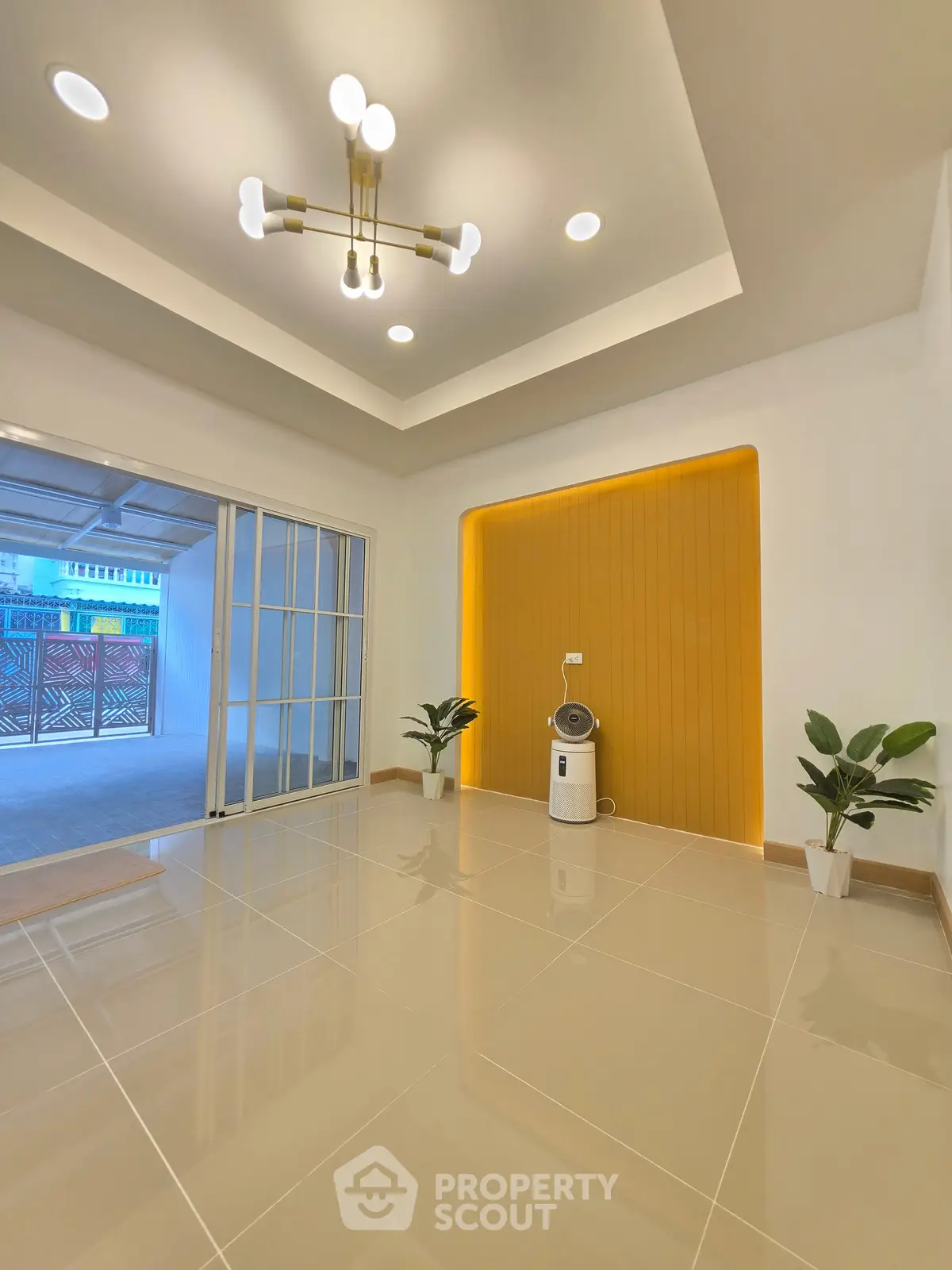 Modern interior with sleek lighting and sliding glass doors opening to a patio, featuring elegant floor tiles.