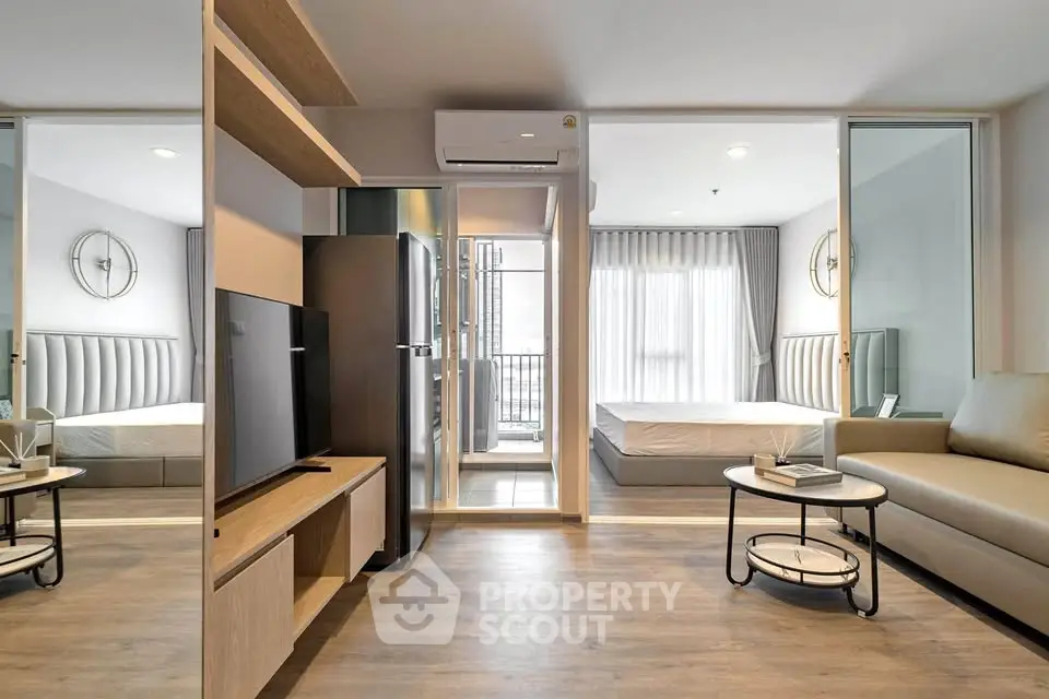 Modern open-plan living room with sleek furniture and large windows in a stylish apartment.