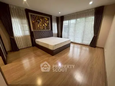Spacious bedroom with elegant decor and large windows for natural light