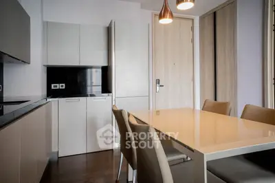 Modern kitchen with sleek cabinetry and dining area in contemporary apartment