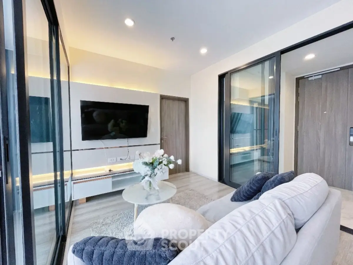 Modern living room with sleek design and large TV, perfect for relaxation.