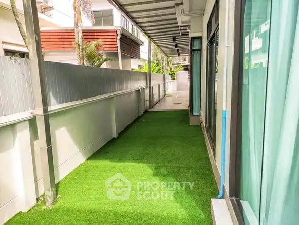 Charming outdoor corridor with artificial grass and modern design, perfect for relaxation and leisure.