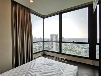Luxurious bedroom with panoramic city view and floor-to-ceiling windows