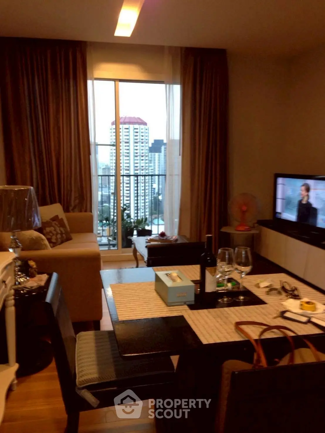 Cozy living room with city view, modern furniture, and elegant decor in a high-rise apartment.