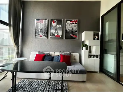 Modern living room with stylish decor and city view, featuring a cozy sofa and elegant wall art.