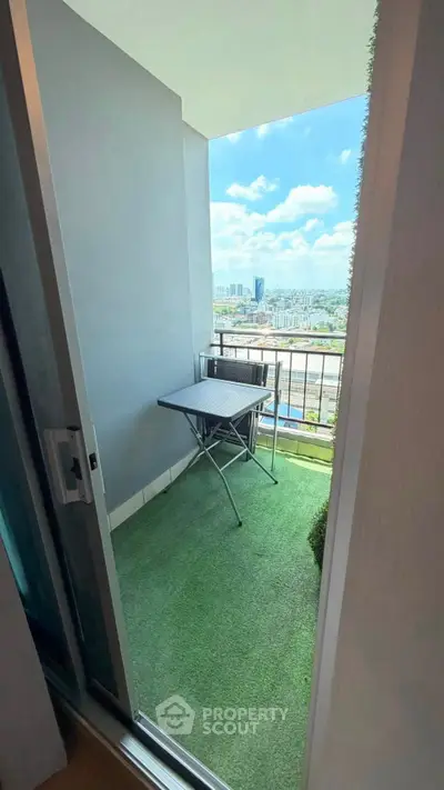 Charming balcony with artificial grass and city view, perfect for relaxation.