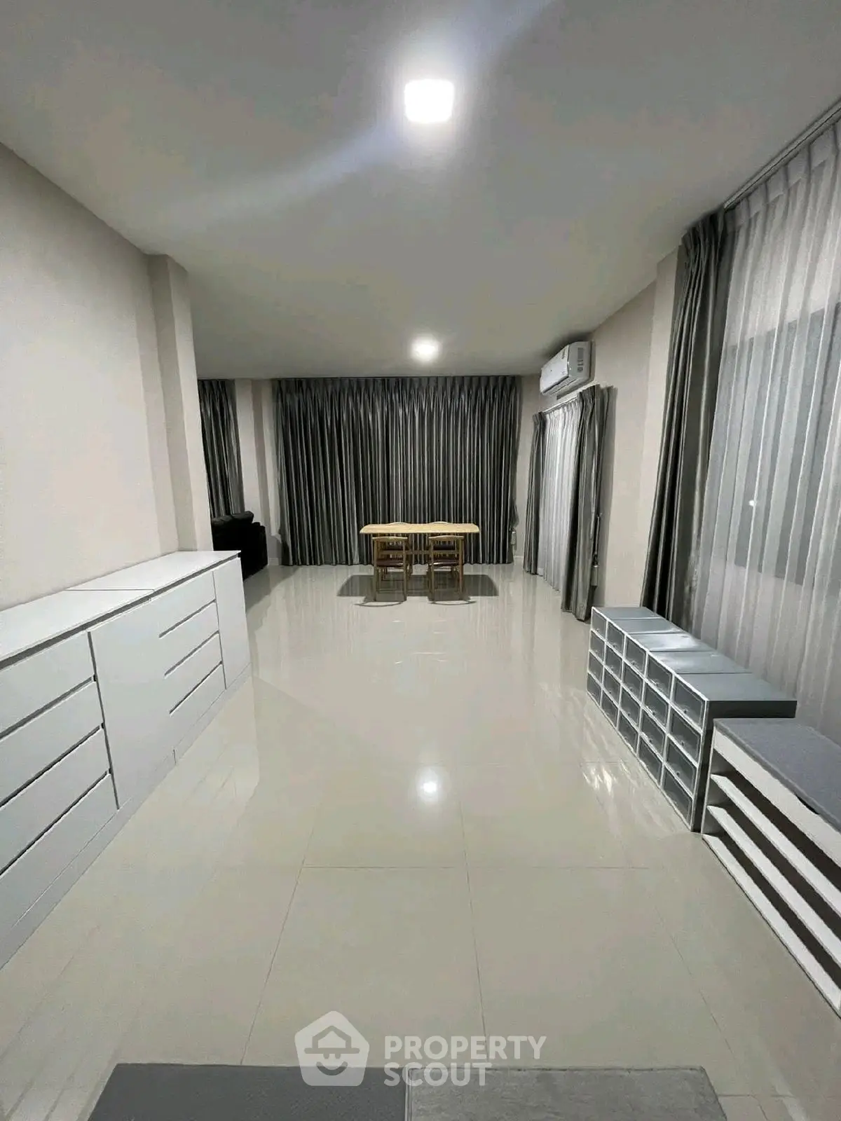 Spacious modern living room with sleek furniture and large windows.