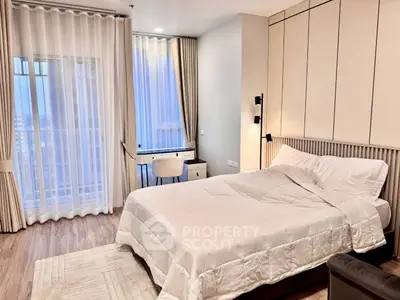 Modern bedroom with elegant decor and natural light, featuring a cozy bed and stylish curtains.