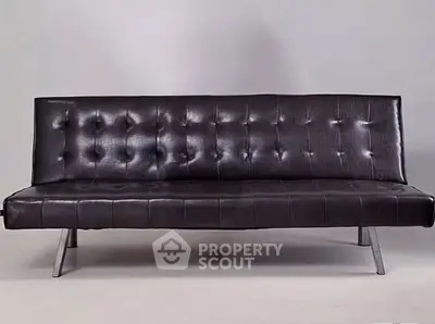 Sleek modern black leather sofa with chrome legs, perfect for contemporary living room decor.