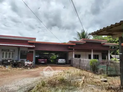 Charming single-story home with carport and rustic surroundings, perfect for countryside living.