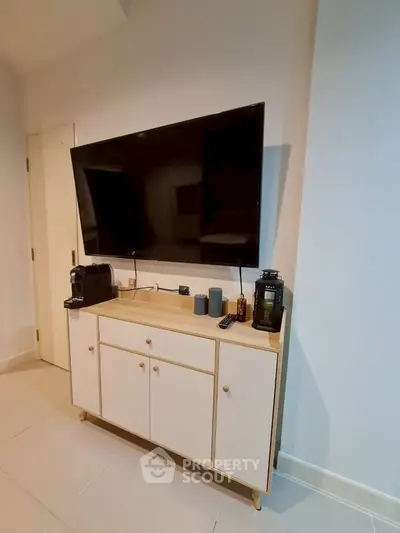 Modern living room with wall-mounted TV and stylish cabinet, perfect for entertainment and relaxation.