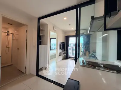 Modern apartment interior with open kitchen and living area, featuring sleek design and natural light.