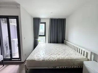Modern bedroom with large window and washing machine on balcony