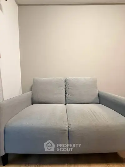 Cozy two-seater gray sofa in a minimalist living room setting.