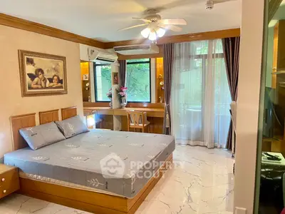 Spacious bedroom with elegant decor and large windows offering natural light and garden view.
