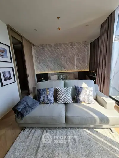 Modern living room with stylish sofa and elegant decor in a sunlit apartment.