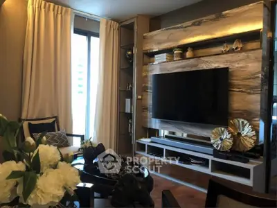 Luxurious living room with modern decor and large TV, featuring elegant curtains and stylish shelving.
