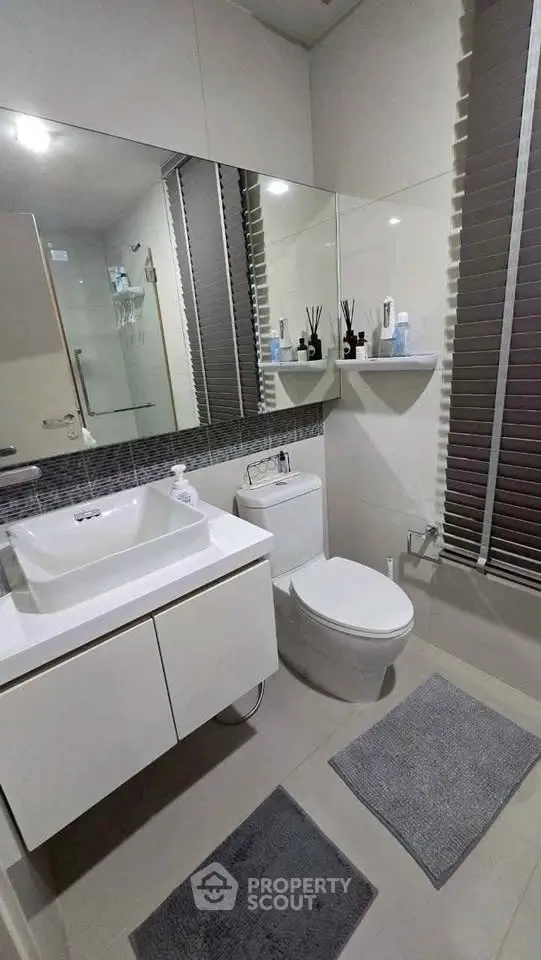 Modern bathroom with sleek fixtures and large mirror in a contemporary home.