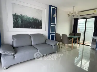 Modern living room with sleek gray sofa and elegant dining area