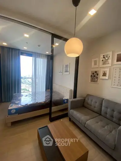 Modern studio apartment with stylish decor and city view, featuring a cozy living area and comfortable bed.