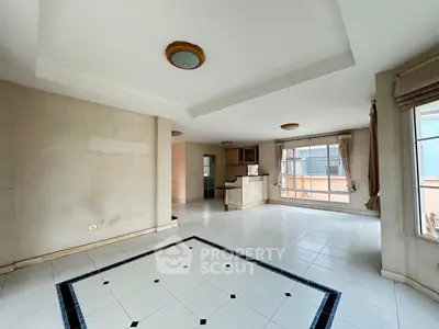 Spacious open-plan living area with large windows and modern kitchen