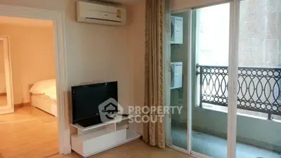 Cozy living room with TV, air conditioning, and balcony access in modern apartment.
