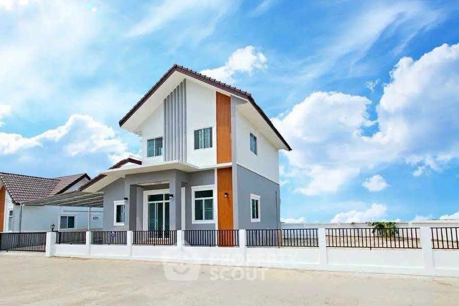 Modern two-story house with sleek design and bright exterior under a clear blue sky.