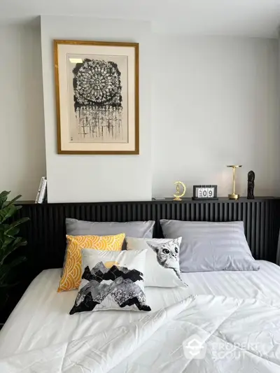 Modern bedroom with stylish decor and unique artwork above bed