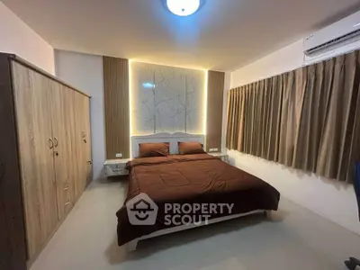Modern bedroom with stylish lighting and cozy decor, featuring a comfortable bed and ample storage space.
