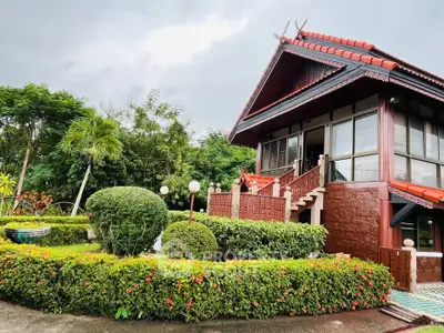 Charming traditional-style house with lush garden and unique architectural features.