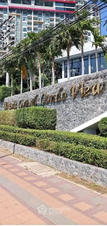 Luxurious condo entrance with lush landscaping and modern architecture.