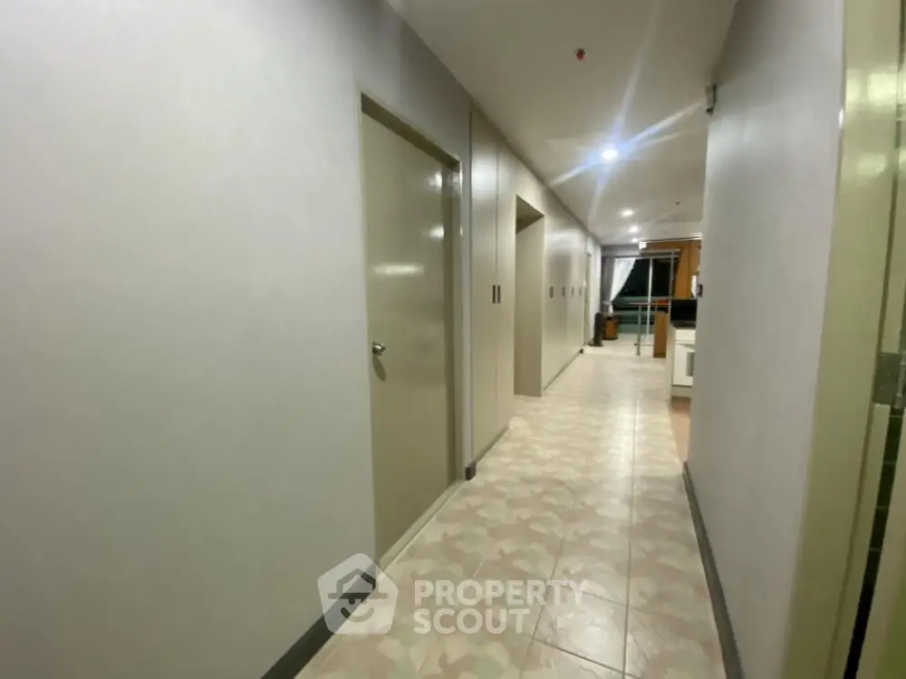 Spacious corridor with modern design and tiled flooring in residential building.