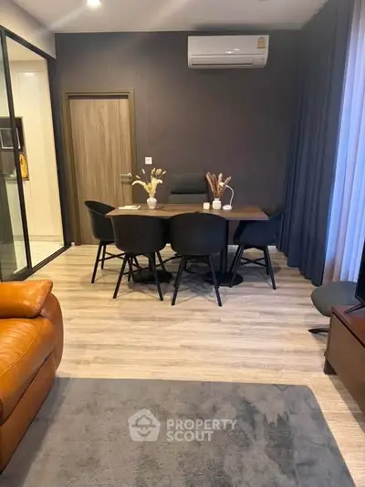 Modern living room with stylish dining area and sleek air conditioning unit.