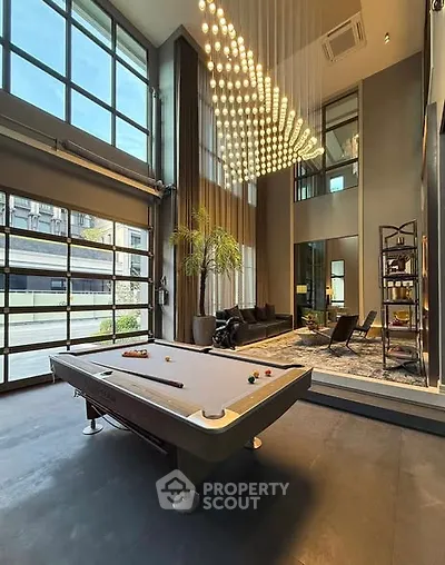 Luxurious living room with high ceilings, pool table, and modern decor