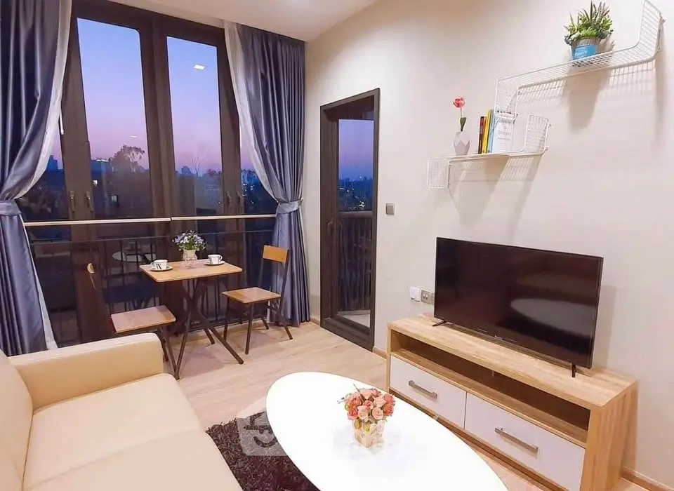 Charming living room with balcony view, cozy seating, and modern decor.
