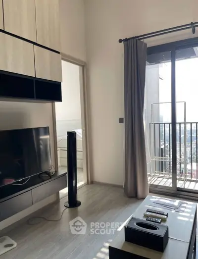 Modern living room with balcony and city view, featuring sleek furniture and natural light.
