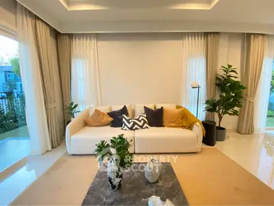 Elegant living room with modern decor, large windows, and stylish furniture, perfect for relaxation and entertainment.