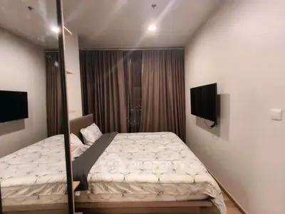 Modern bedroom with cozy bed and wall-mounted TV in a stylish apartment.