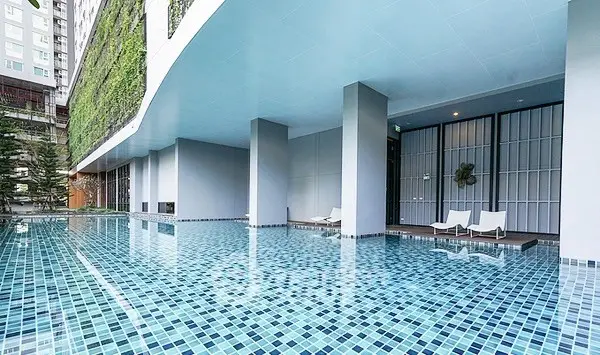 Luxurious modern apartment complex with stunning poolside area and sleek architectural design.