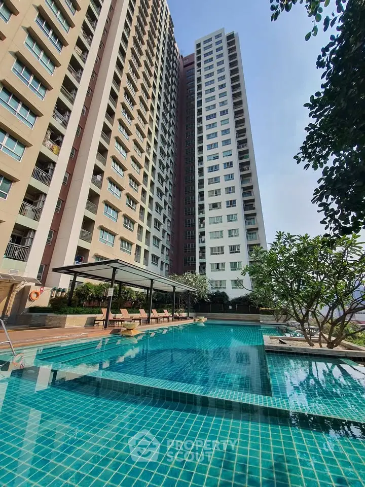 Stunning high-rise building with a luxurious pool and lush greenery, perfect for modern urban living.