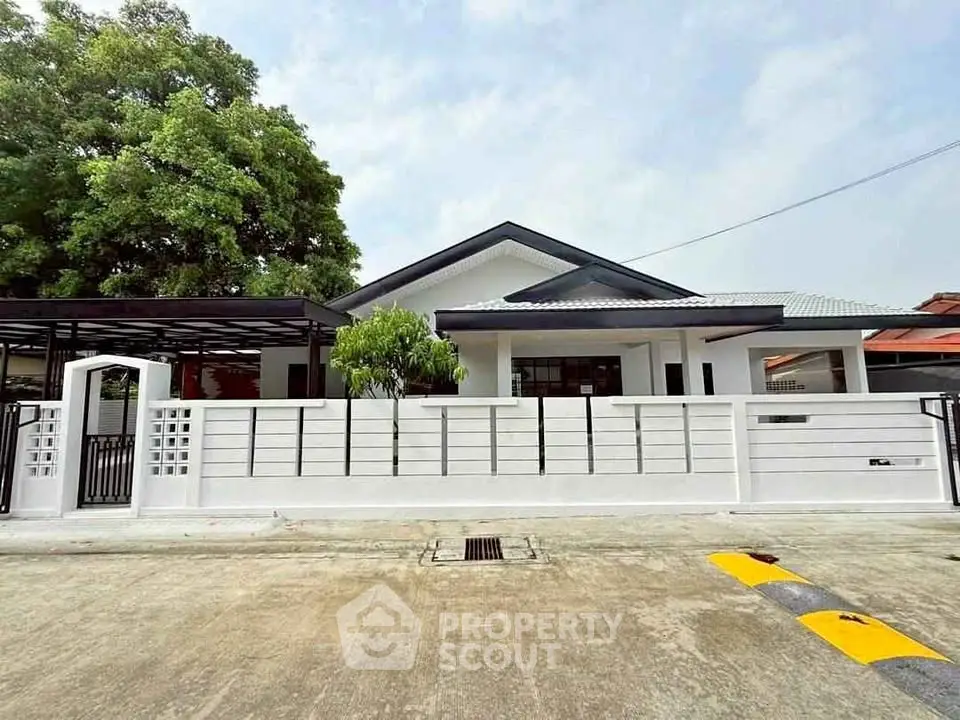 Charming single-story home with modern fence and lush greenery in a serene neighborhood.