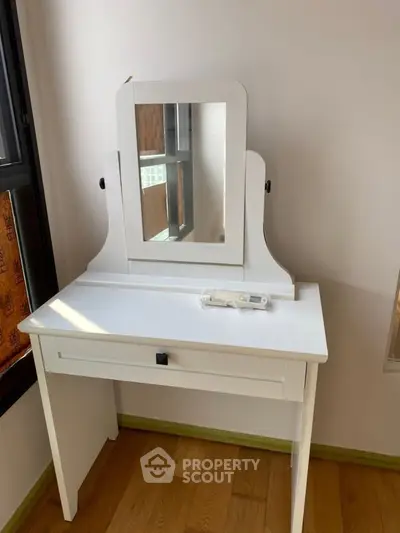 Charming white vanity table with mirror in a cozy corner, perfect for enhancing bedroom elegance.