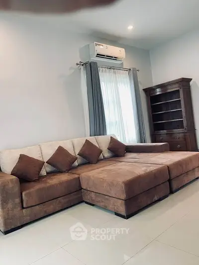 Spacious living room with modern sectional sofa and elegant wooden bookshelf.